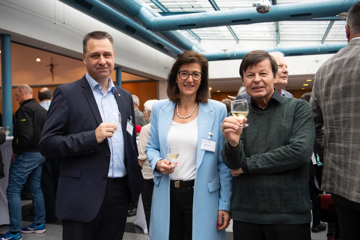 Von links: Stadtrat Stefan Lenz, Stadträtin Sandra Elliscasis (beide FDP) und Parlamentarier Toni Zweifel (Die Mitte). Man sieht drei Menschen bei einem Apéro.